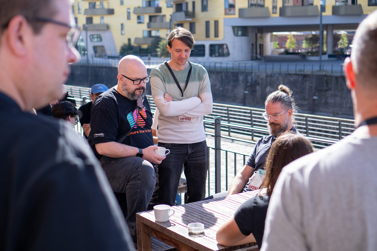Me together with some other people standing around a table on the sunny terrace.