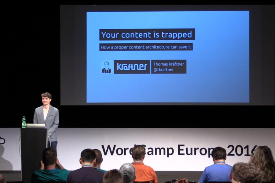 Me standing on the stage of WCEU 2016 in Vienna. Behind you can see the first slide of my presenation: Your content is trapped.